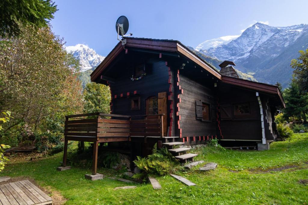 a small wooden house with mountains in the background at Mazot du Mont-Blanc w/View, Terrace & Stove, (Sleeps 4) - Happy Rentals in Chamonix