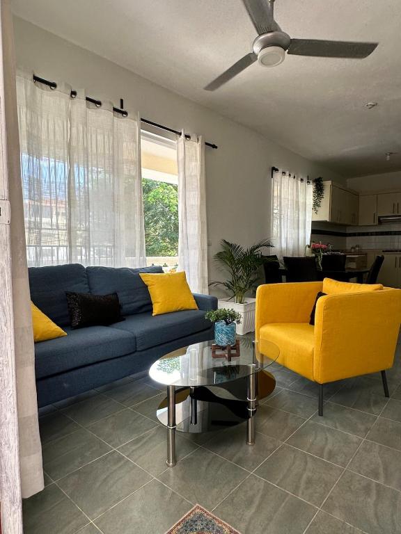 a living room with a blue couch and yellow chairs at las gaviotas in Bayahibe