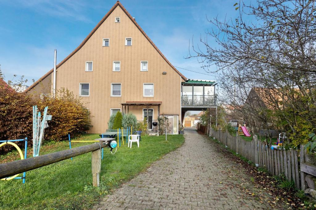 a large brown building with a fence in front of it at Bachbubenhof in Hüfingen
