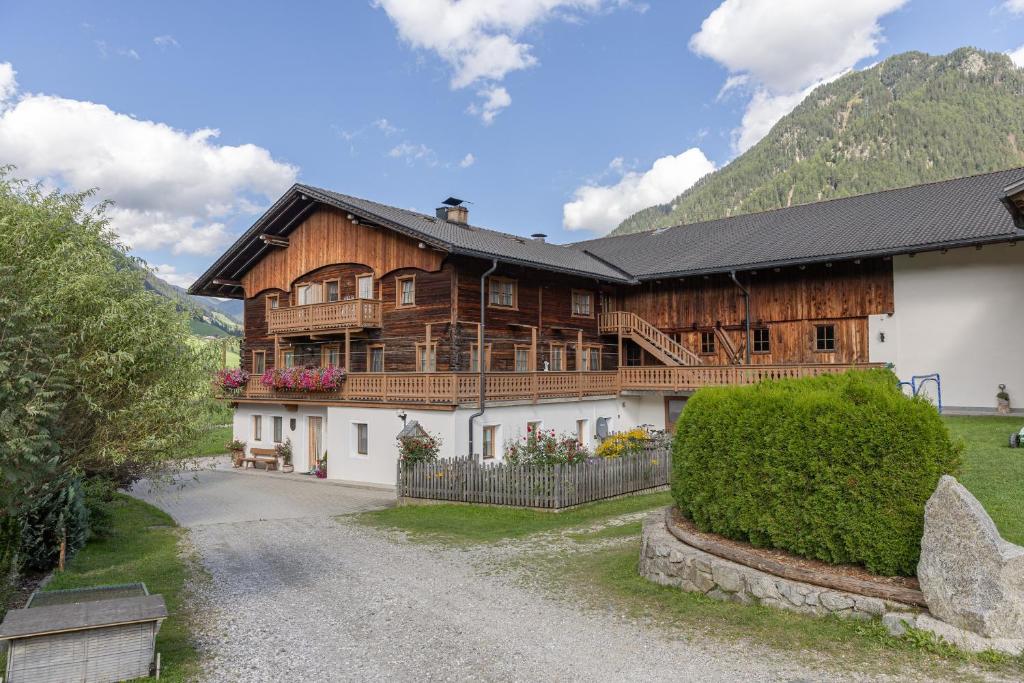 a large wooden house with a mountain in the background at Obermarhof Gsies in Prateria