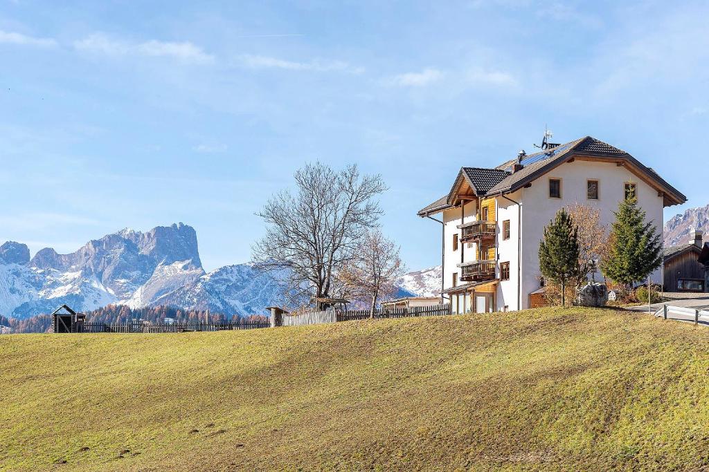 Ein Haus auf einem Hügel mit Bergen im Hintergrund in der Unterkunft Ciablun in Wengen