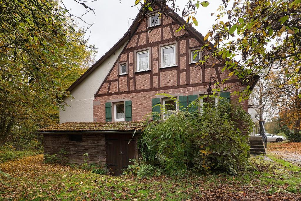 a house with a gambrel roof and a garage at Haus an der Landhege in Mainhardt
