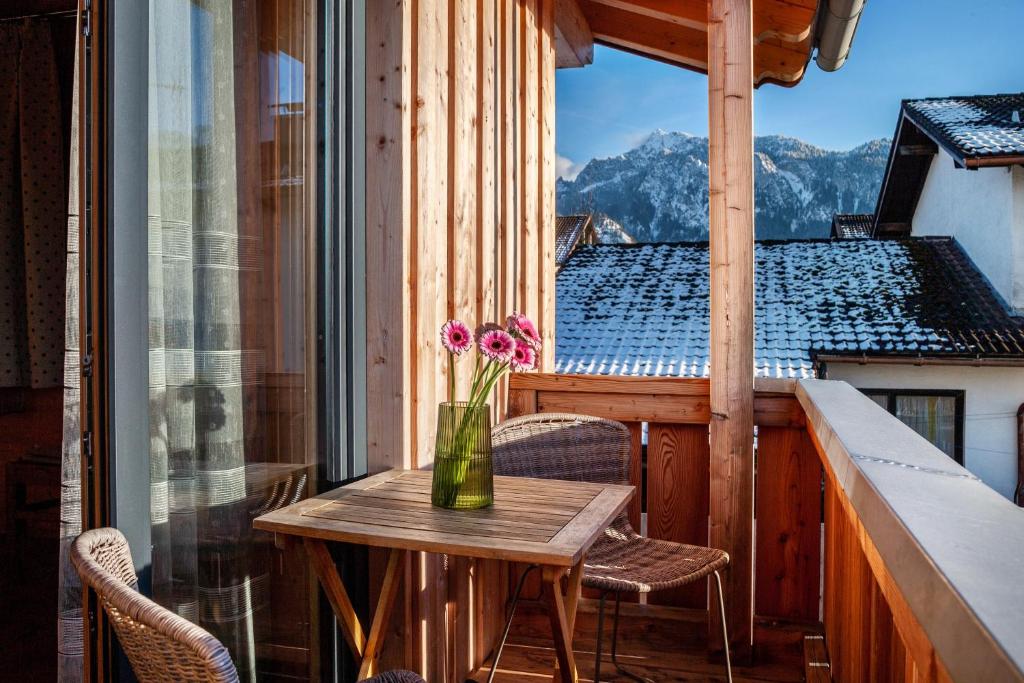 a table on a balcony with a vase of flowers at Ferien Bei Mari in Schwangau