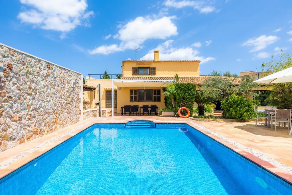 a villa with a swimming pool and a house at Can Magraner in Port de Pollensa