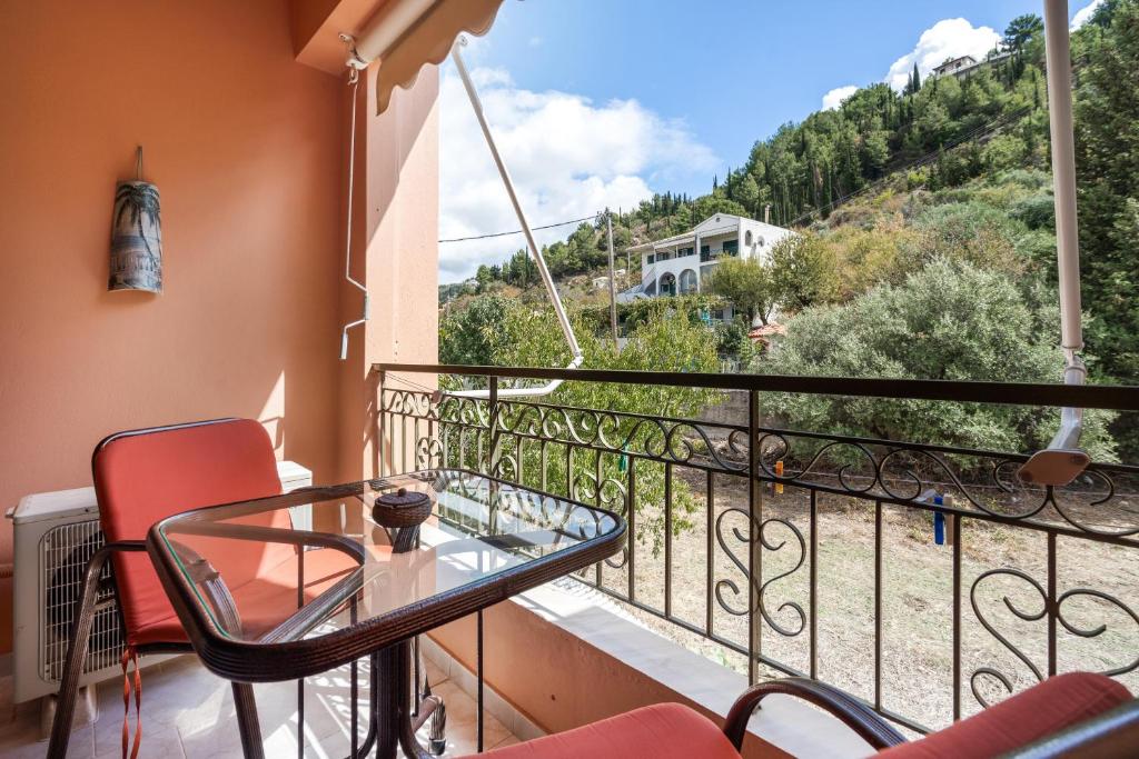 a balcony with a glass table and chairs at Nontas Homes 34 in Kalamitsi