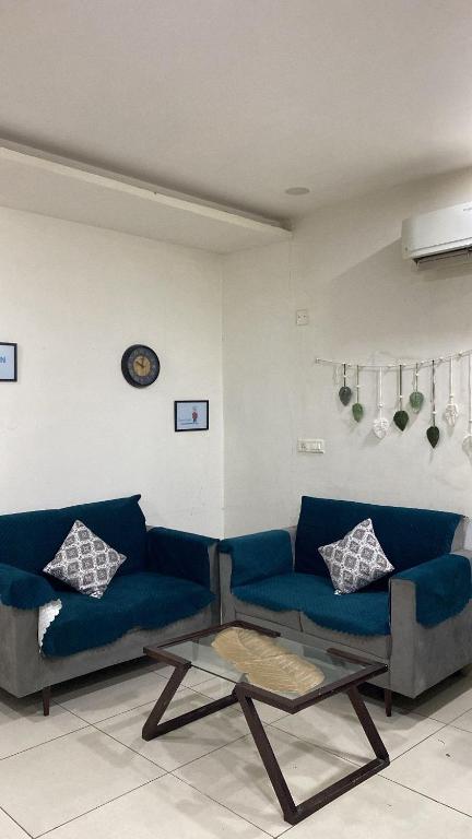 a living room with a blue couch and a table at The Horizon Blue in Zirakpur