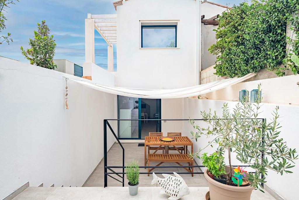 a balcony with a table and potted plants at Appartamentino in Bari Sardo