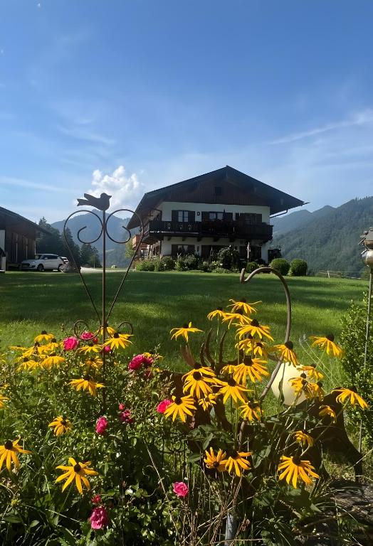 a garden with flowers in front of a house at Ferienwohnung Hochfelln in Ruhpolding