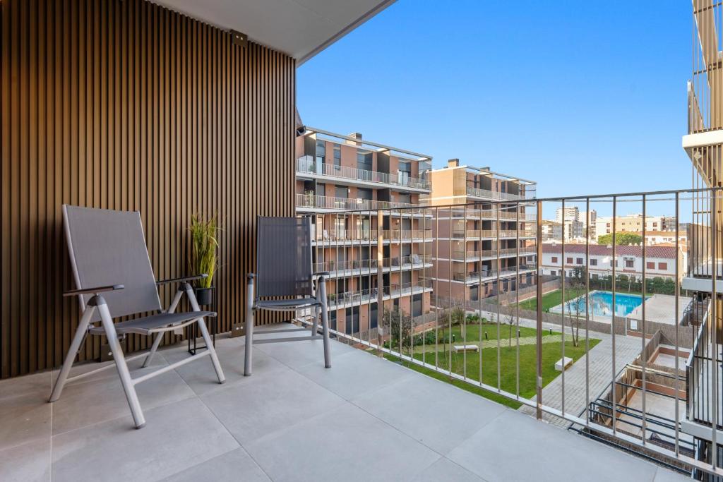 a balcony with two chairs and a view of a building at Costa Dorada Perle in Calafell