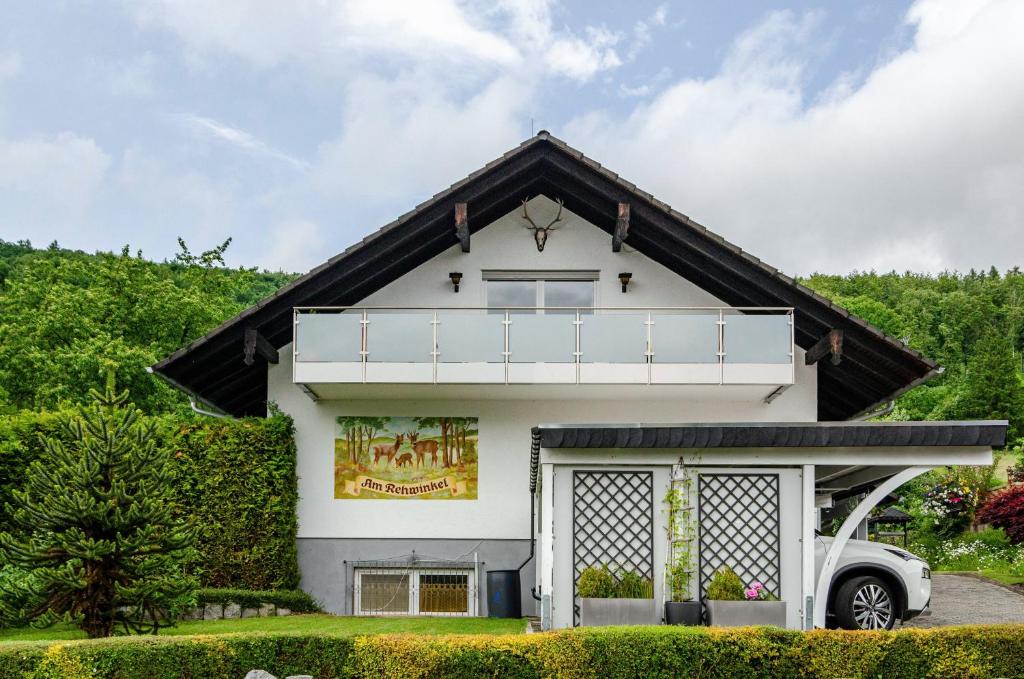 a white house with a black roof at Ferienwohnung am Rehwinkel in Fuldatal