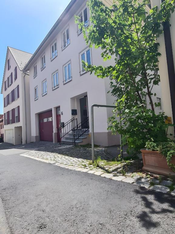 a white building with a tree in front of it at Stadtzimmer Im Entenmoos in Bad Waldsee