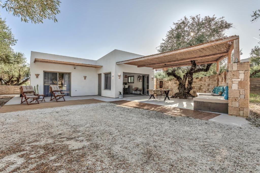 an outdoor living area with a fireplace and a patio at Natura Oliva House in Alikanas
