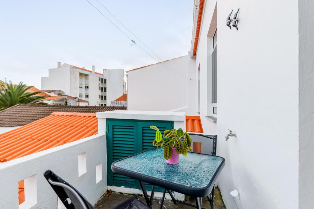 a small table on a balcony with a plant at Garden View Apartment in Horta