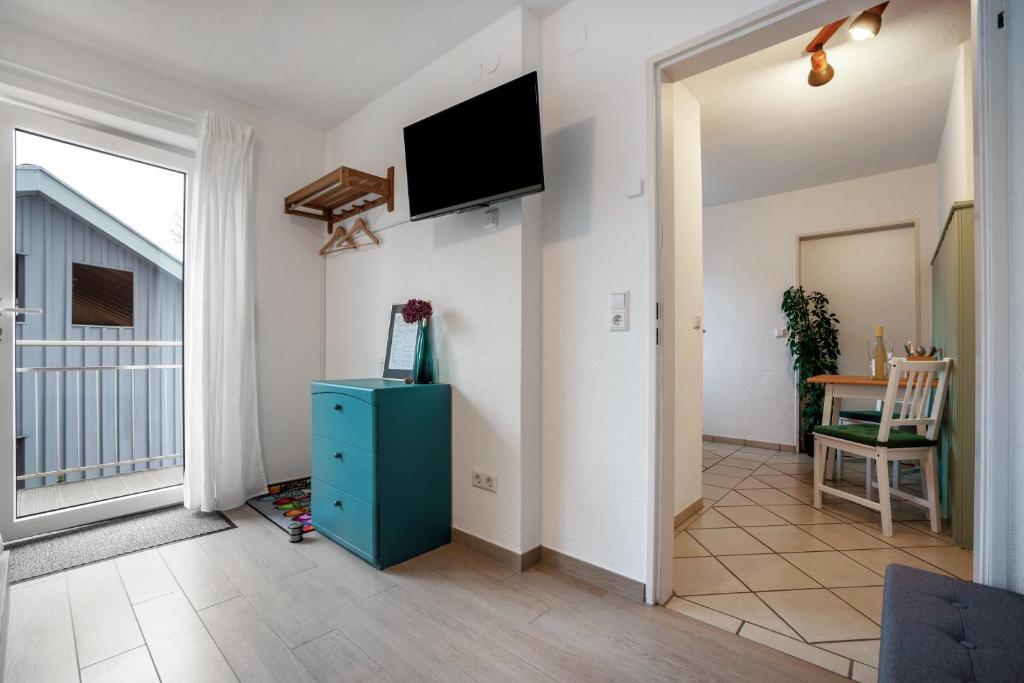 a living room with a blue cabinet and a tv on the wall at Tinas Ferienwohnung in Hergensweiler