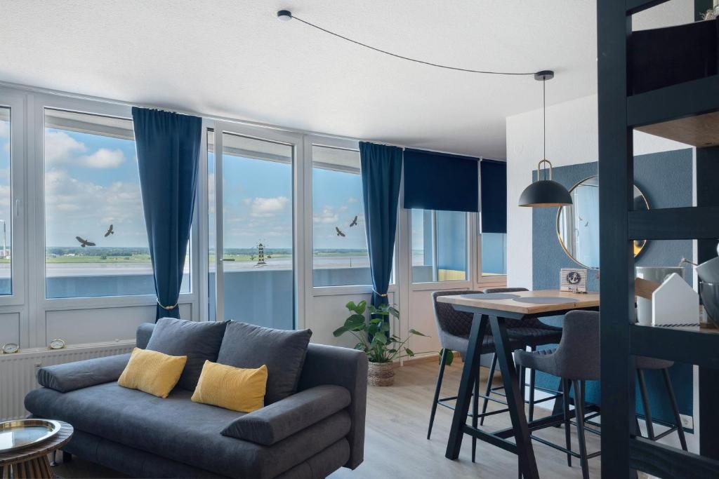 a living room with a couch and a table with a view of the ocean at Ferienwohnung Clara in Bremerhaven