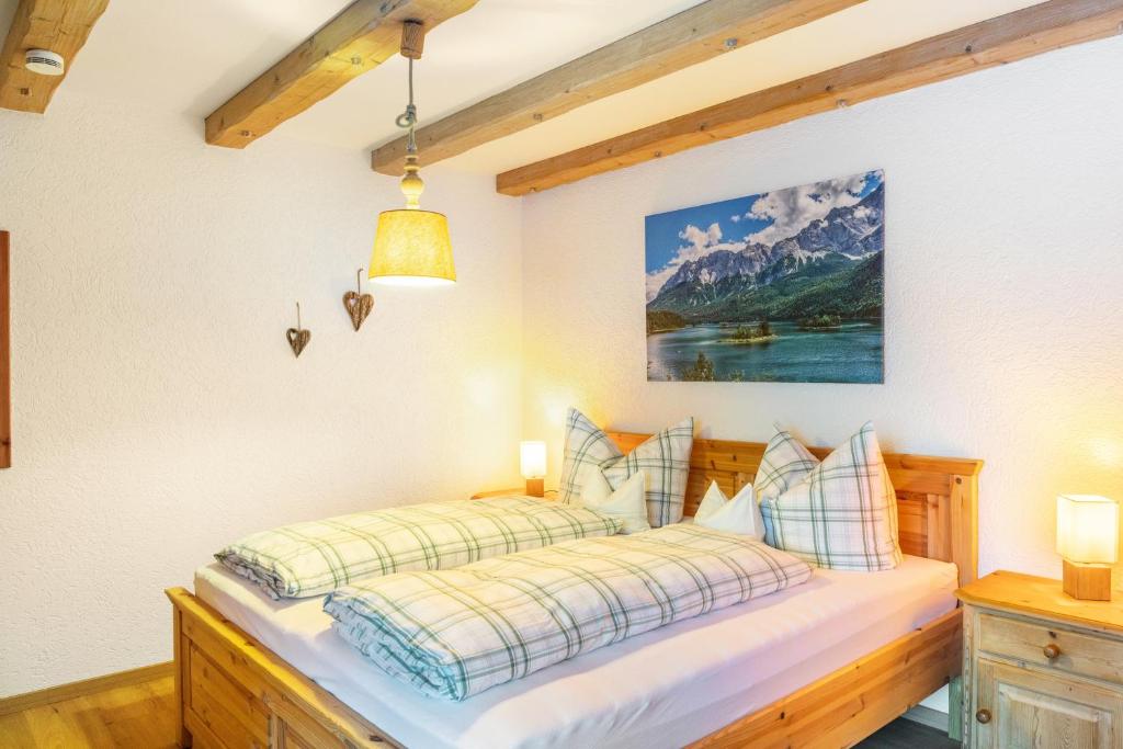 a bedroom with a bed with a picture on the wall at Ferienwohnung Reintal in Grainau