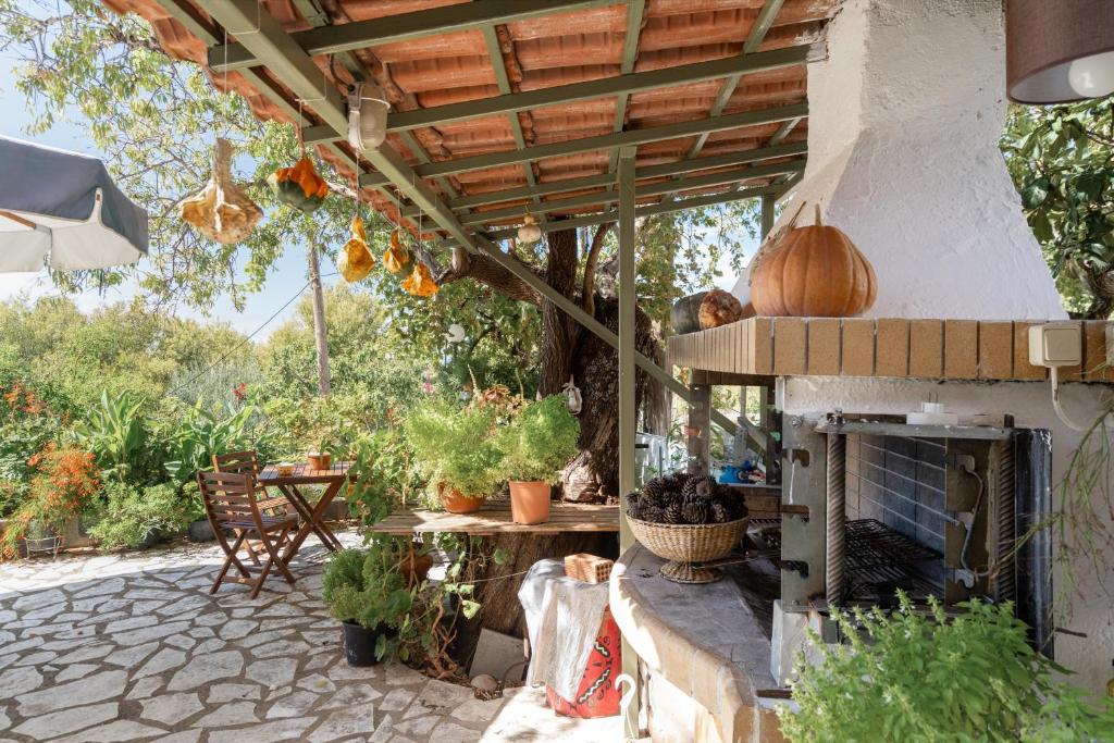 a patio with an outdoor oven with a table and chairs at Nontas Home 20 in Kalamitsi
