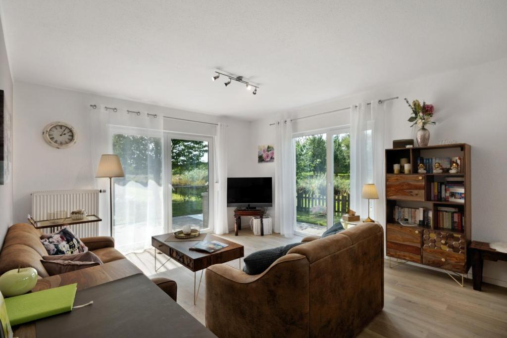 a living room with two couches and a tv at Ferienhaus Apfelzauber in Twielenfleth