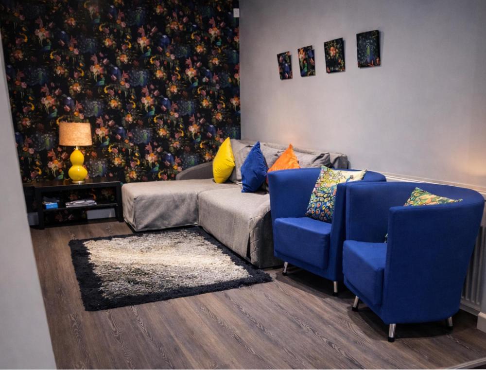 a living room with a couch and two blue chairs at Saphire Apartments Spacious 1 Bed Apartment Sleeps 6 with Free Parking and Garden in Giffnock