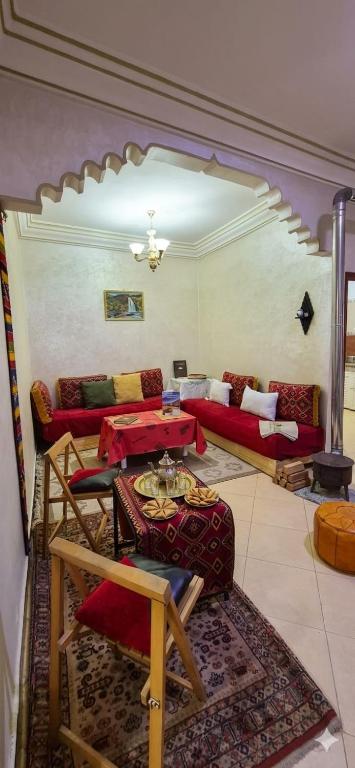 a living room with red couches and a table at Cozy in Midelt - Downtown apartment in Midelt
