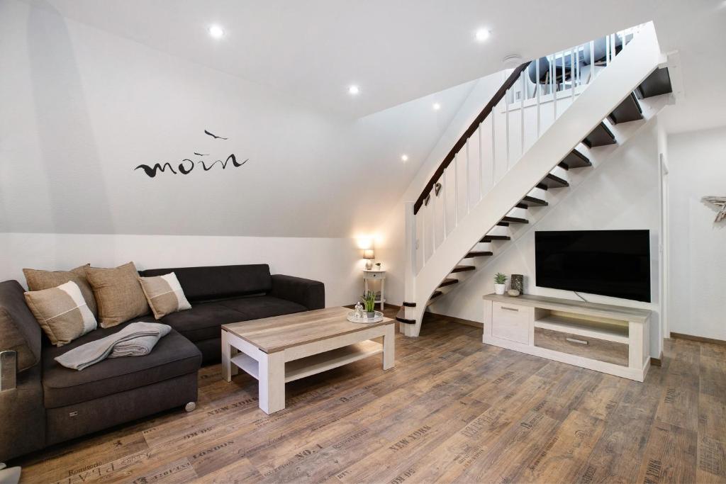 a living room with a couch and a tv and stairs at Kleine Nock in Burg