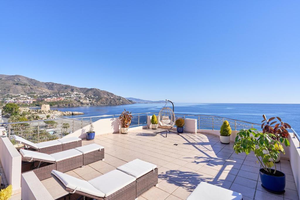 a balcony with chairs and a view of the ocean at Argali Beach Almuñecar in Almuñécar