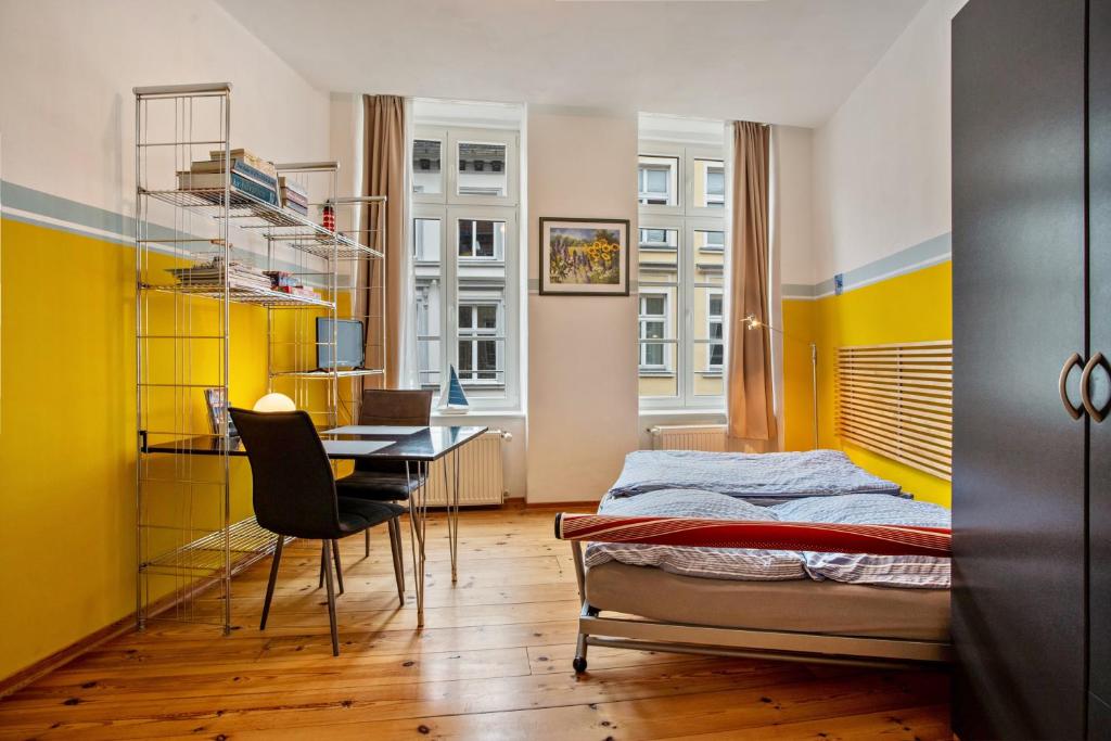 a bedroom with a bed and a desk and a table at Ferienwohnung Rügen in Stralsund