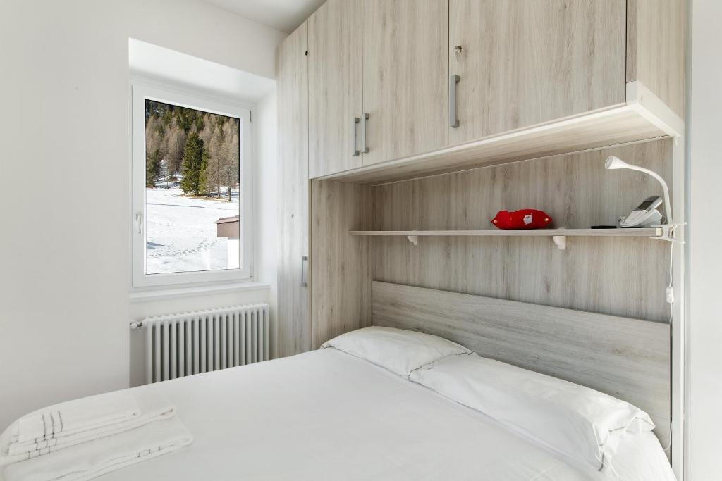 a bedroom with a white bed and a window at Dolomiti e Misurina My dreams in Misurina