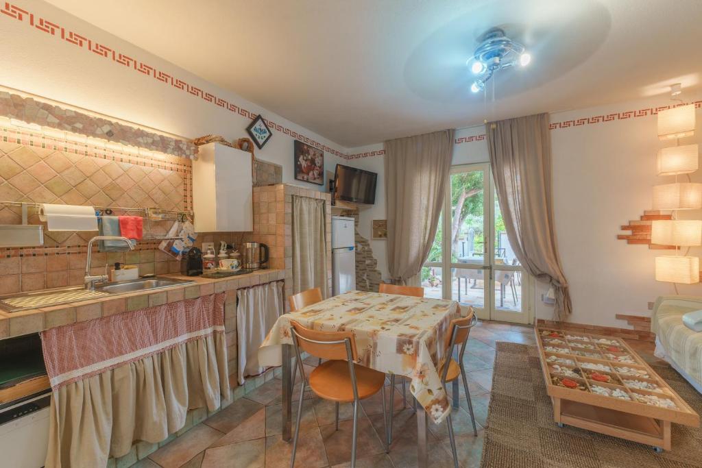 a kitchen and living room with a table and a sink at Villa Marisol Agrustos in Budoni