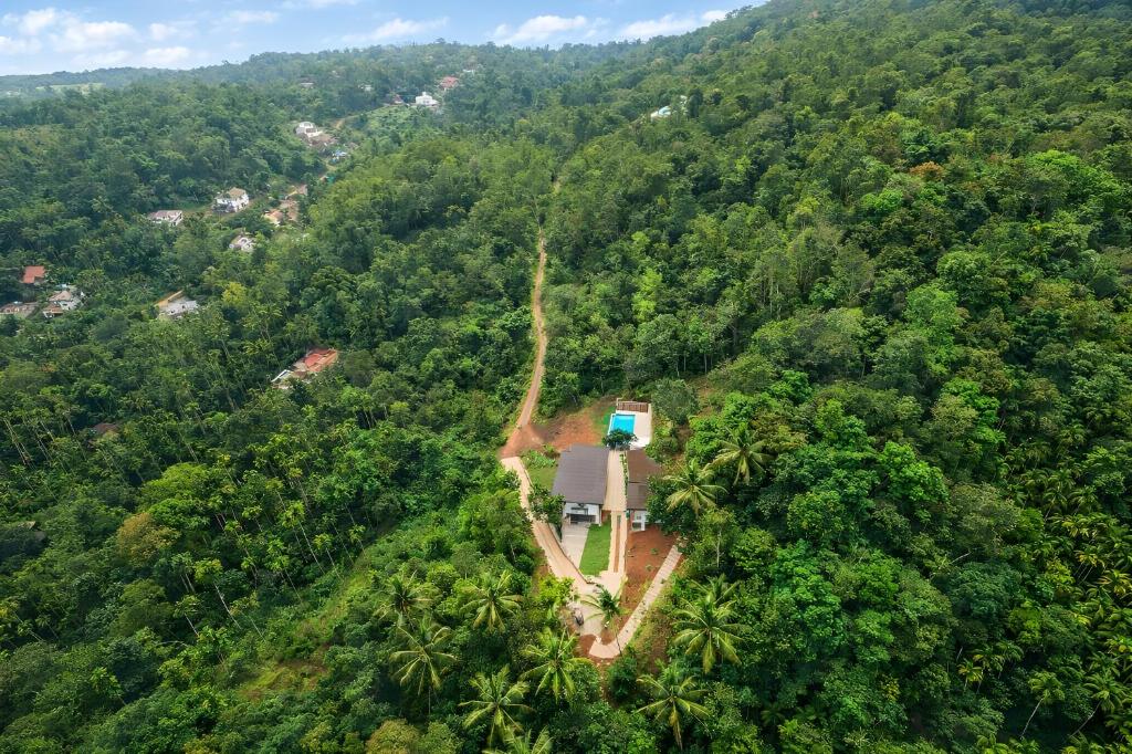 an aerial view of a house in the middle of a forest at Camplights Stays in Tariyod