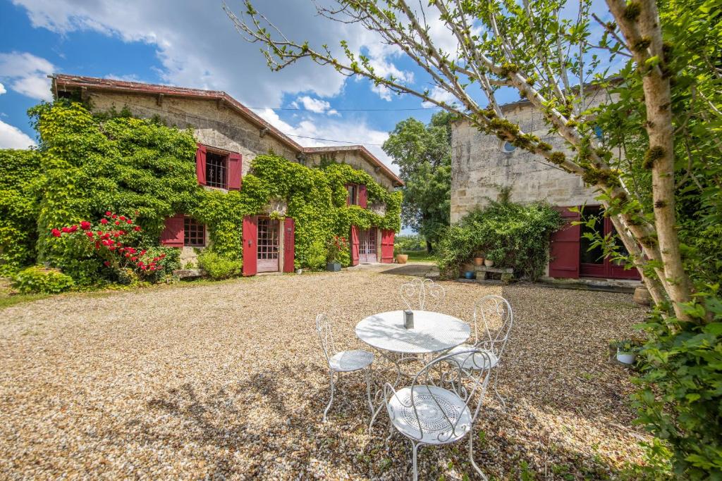 a table and chairs in front of a house at Échappée Bel in Arveyres