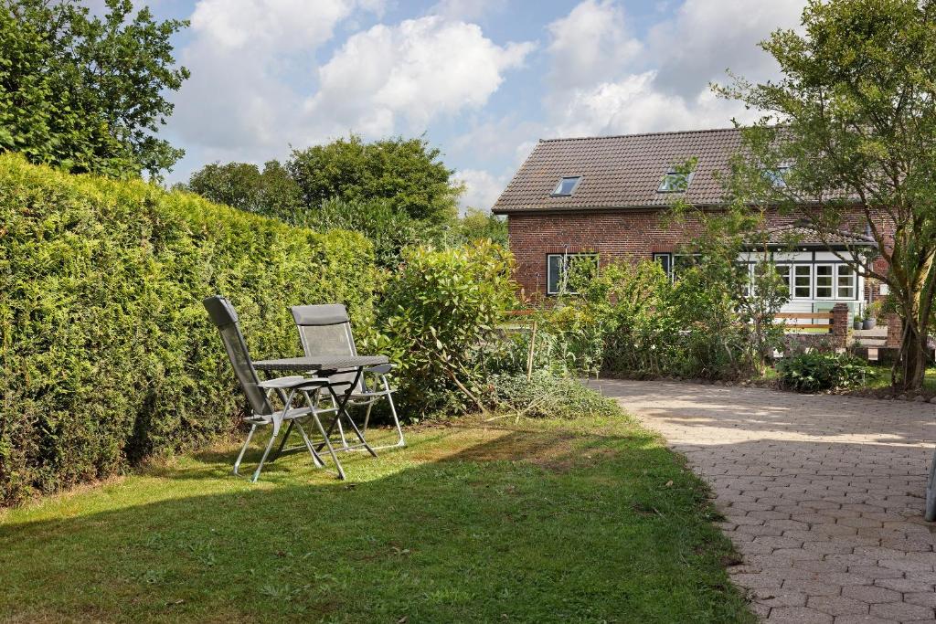 a chair and a table in the yard of a house at Ferienwohnung Thomée in Looft