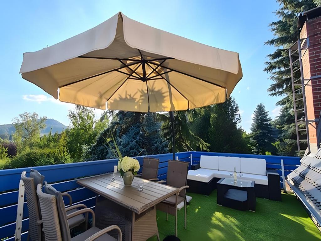 a patio with a table and a large umbrella at Carpe Diem - Ferienwohnung in Görlitz