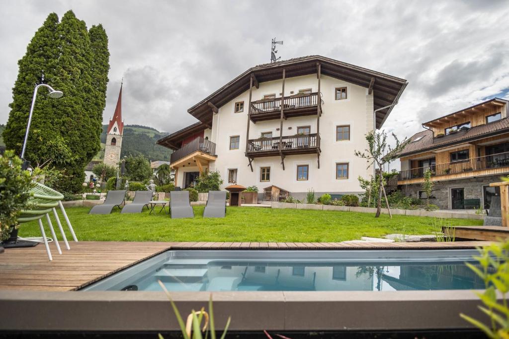 a villa with a swimming pool in front of a building at Residence Grünbacher in Issengo