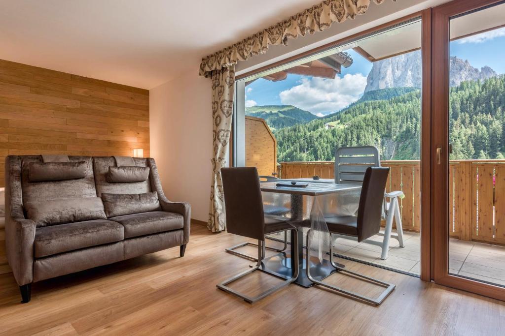 a living room with a glass table and a couch at Garni Hotel Gardena App Dolomites 3 in Santa Cristina Gherdëina