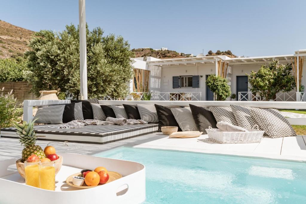 a pool with a couch and a bowl of fruit at Ow Andros Suite 3,Private Whirlpool in Andros