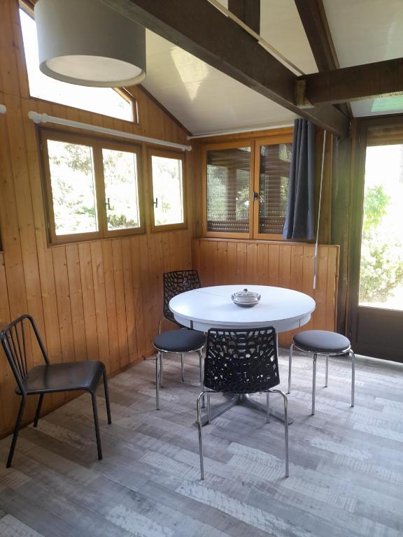 a room with a white table and chairs and windows at Chalet Dominique in Azzana