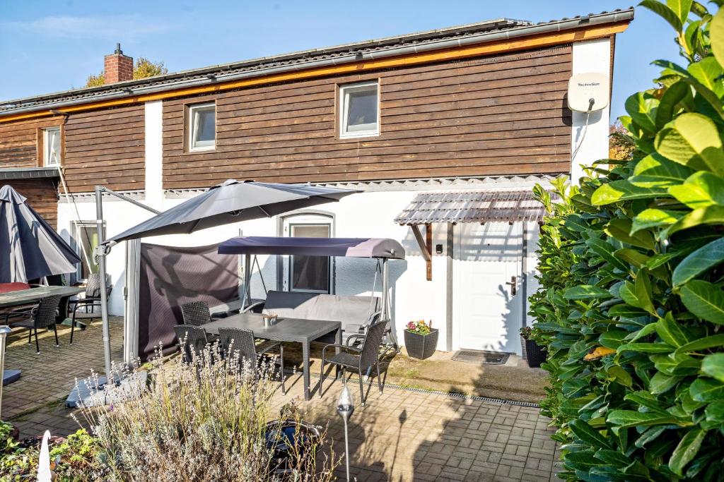a patio with a table and umbrella in front of a house at tierfreundliche Ferienwohnung in Adamshoffnung