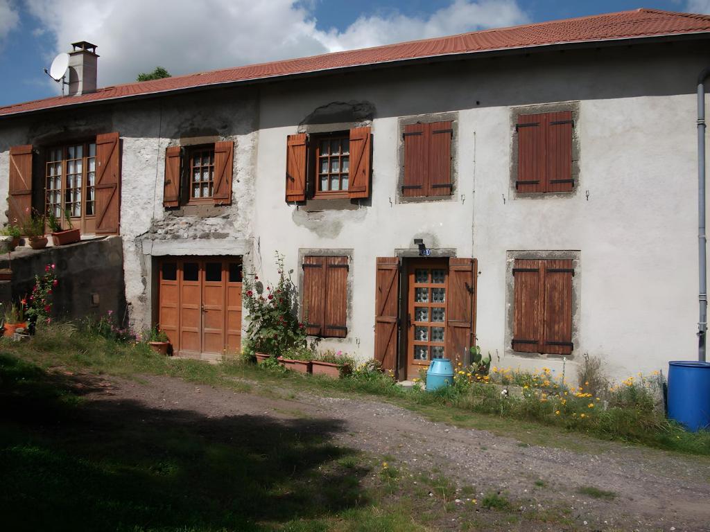 an old white house with wooden doors and windows at Le Paillassou in Blanzac