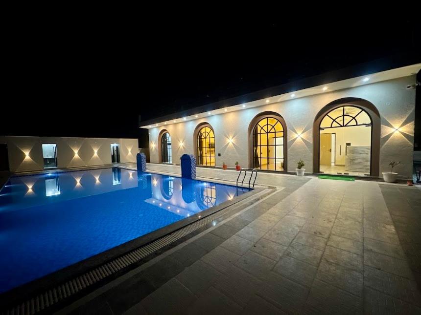a large swimming pool in a building at night at iv hotel Ajmer in Madār