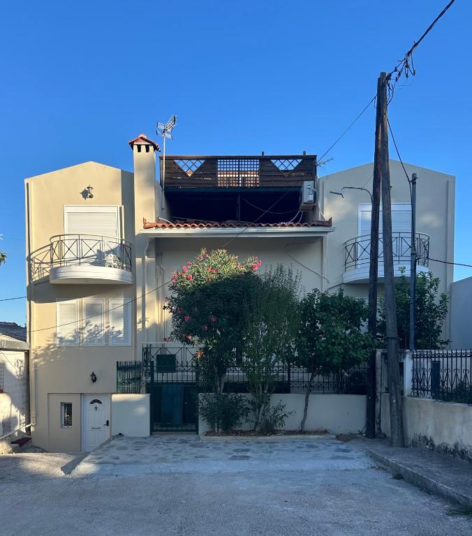 a white house with a fence and a tree at Artemida Beach House in Artemida