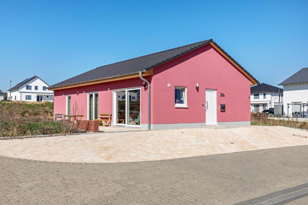 a pink house with a driveway in front of it at Feel Free Apartment in Rheinböllen