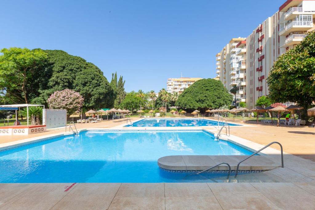 a swimming pool in a resort with trees and buildings at Apartamento Agata 2024 in Benalmádena