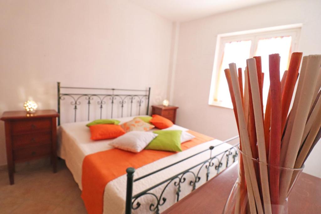 a bedroom with a bed with orange and green pillows at Casa Vacanze Martina a Otranto in Otranto