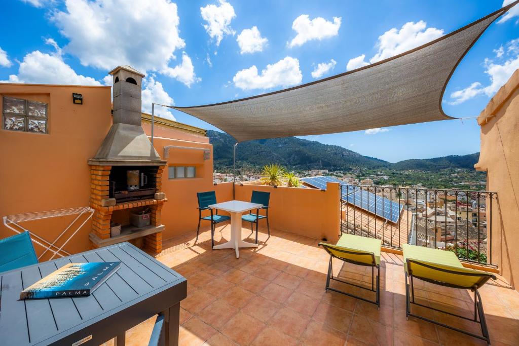 a balcony with a table and chairs and a fireplace at Eliasneil in Andratx