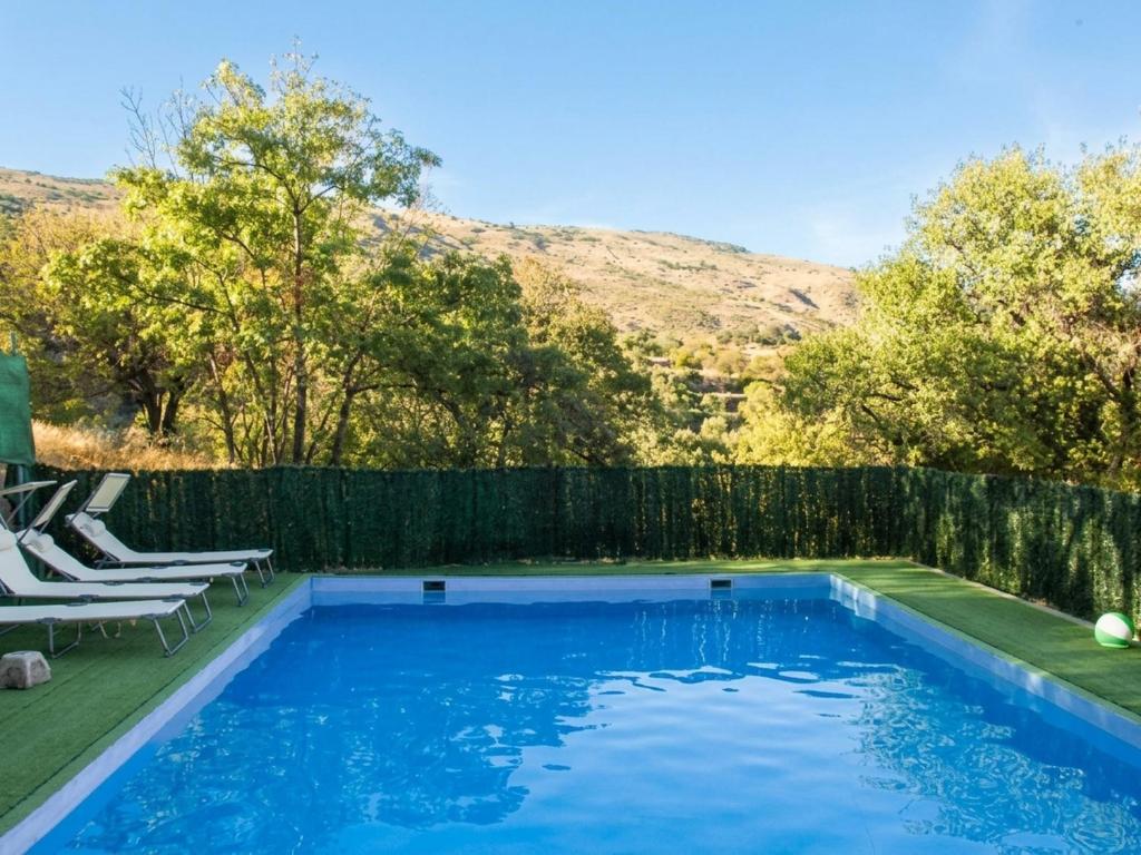 a swimming pool in a backyard with a fence at El Rincón de Muñoz - La Alpujarra in Yegen