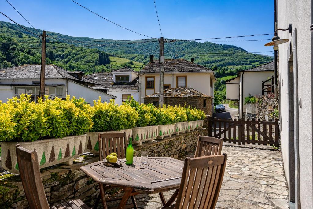 a wooden table and chairs on a stone patio at Puente del Narcea 4 in Cibuyo