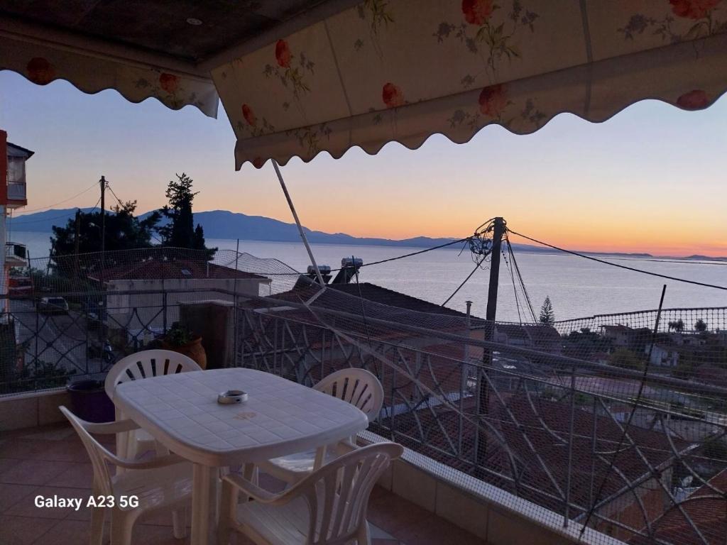 a table and chairs on a balcony with a view of the ocean at Menidi apartment 202 in Menídion