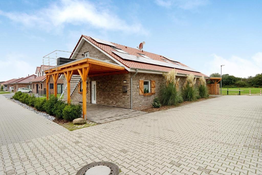 a brick house with a metal roof on a driveway at Speicherhäuschen Maren in Geeste