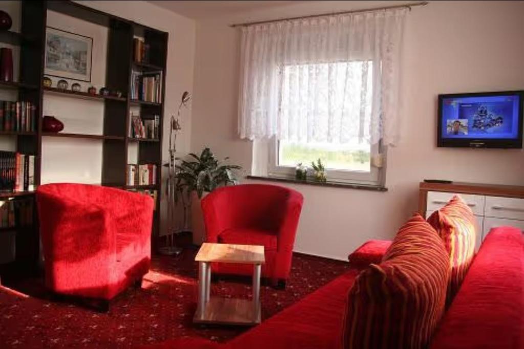 a living room with red chairs and a red couch at Apartment für 2, nicht für Monteure in Niederau